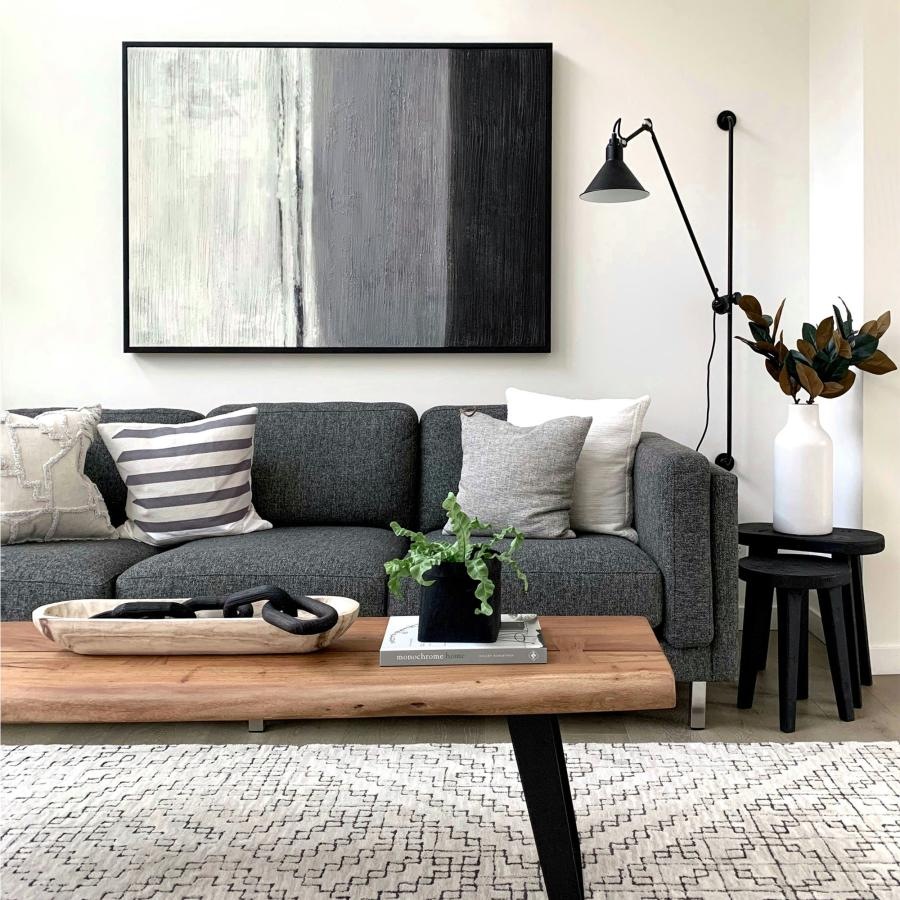 a couch with a coffee table with a plant and decor on it